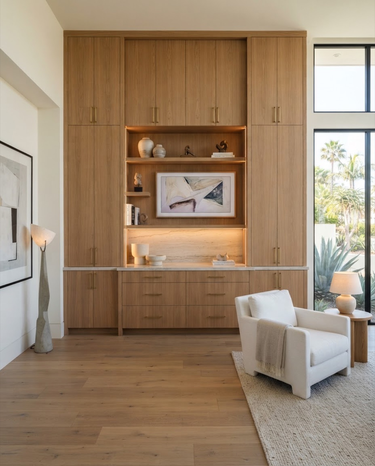 Floor-to-ceiling custom white-oak built-in cabinetry with integrated lighting and a backlit stone niche in a modern San Diego home