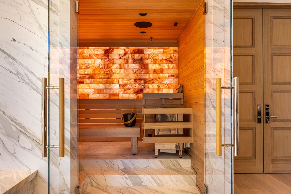 Custom cedar sauna with a backlit Himalayan salt wall and frameless glass door, San Diego