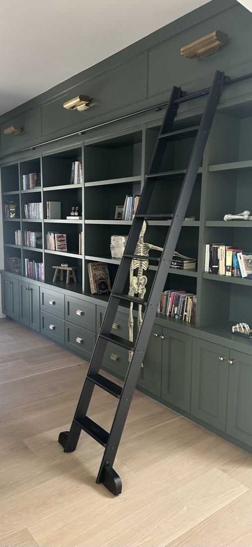 Custom library built-ins in green with a rolling library ladder and integrated lighting, San Diego